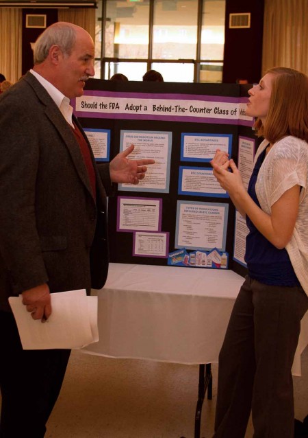 Showcasing Knowledge: An honors senior talks to a guest professor. Honors seniors showcased what they learned in their major over their years at Ferris State. Photo By: Brock Copus | Web Editor