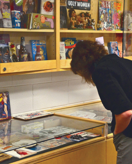 Tracy Busch, assistant professor of history, looks through a collection of objects representing sexism. The women’s collection is on display on the third floor of Starr. Photo By: Brock Copus | Multimedia Editor